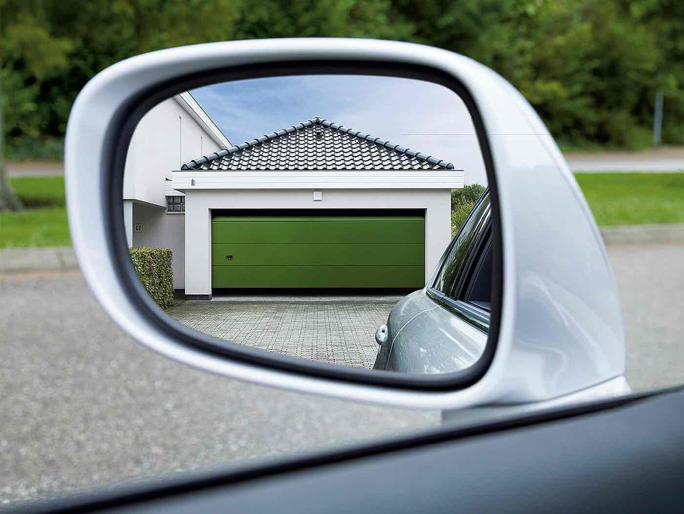 Grön garageport i backspegel
